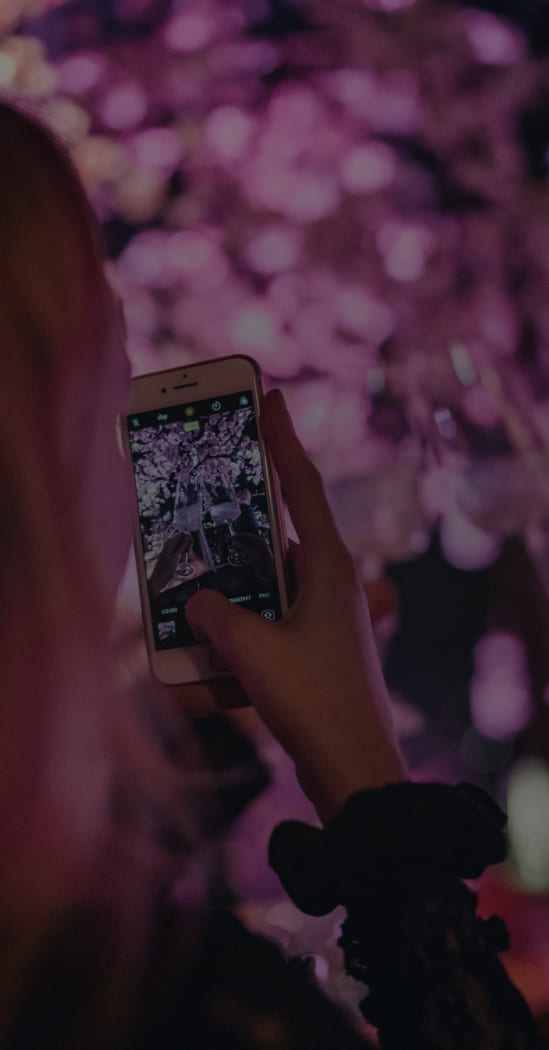 Detailansicht einer Frau mit Handy, die Bild einer Party macht